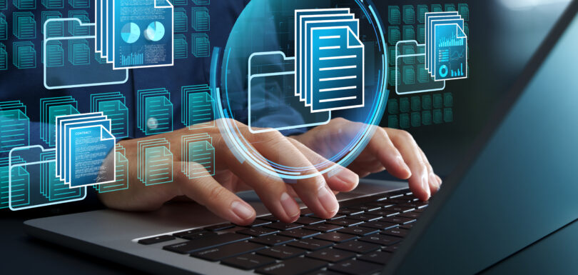Händer som skriver på ett tangentbord på en bärbar dator med digitala fil- och dokumentsymboler överlagrade, som representerar datahantering, kunskapsutbyte, online fillagring eller digital dokumentorganisation.